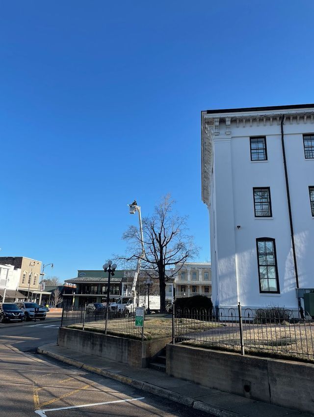 White building next to a street corner with a clear blue sky.