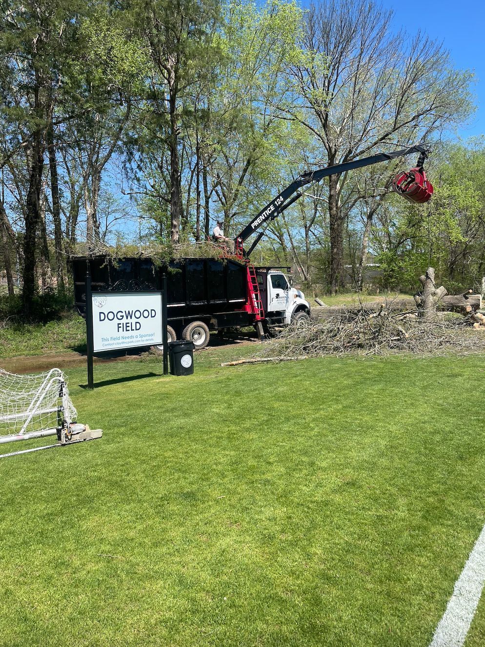 Truck loading brush at Edgewood Park, under blue sky.