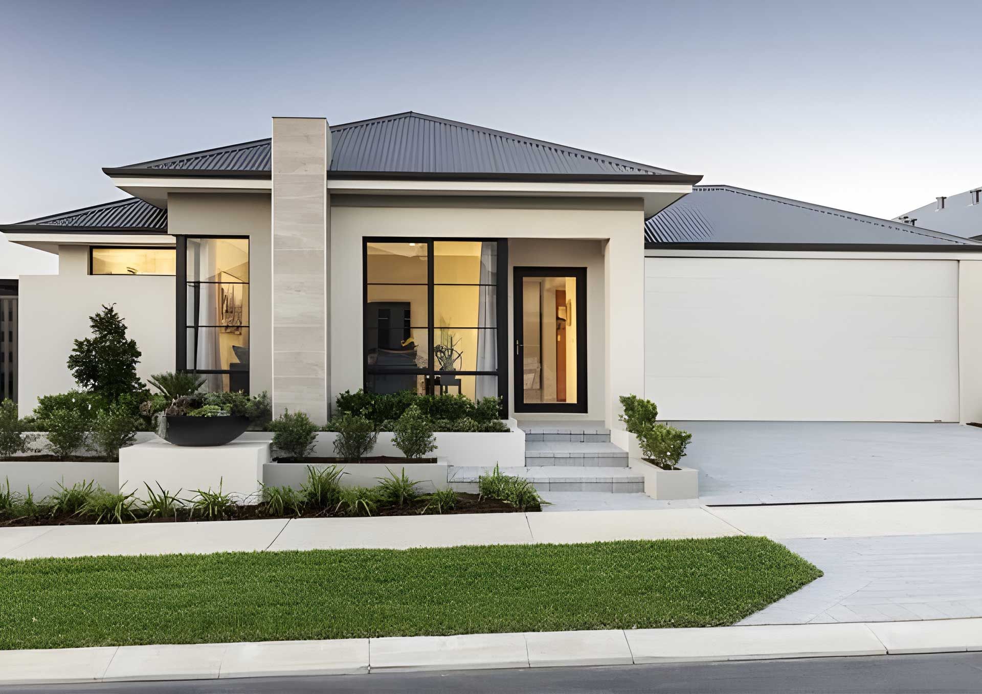 Modern home with a light-colored exterior, dark roof, and garage, with a landscaped front yard and pathway.
