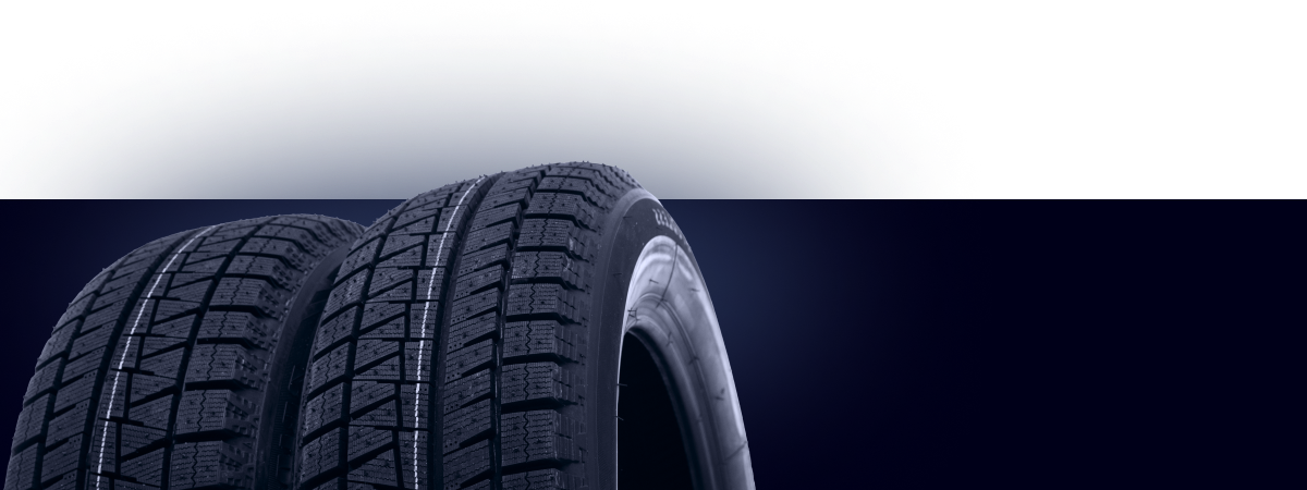 Two tires are stacked on top of each other on a dark background. | Motor Works