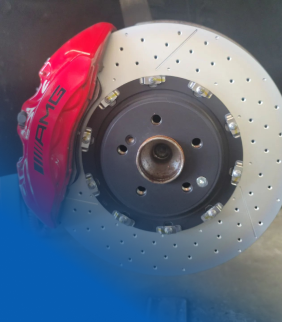 A red amg brake caliper sits on a brake disc | Motor Works