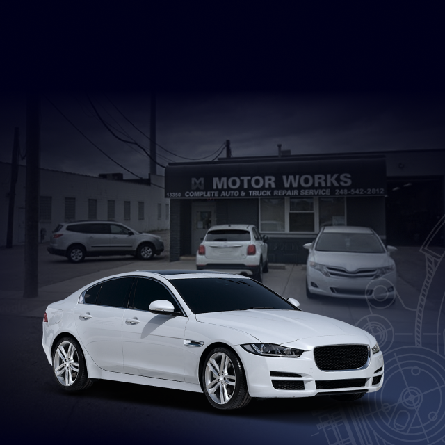 A white car is parked in front of a motor works building | Motor Works