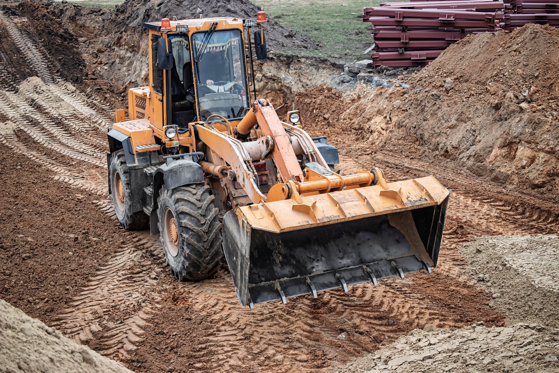 Yellow loader working in a dirt pit, moving earth.