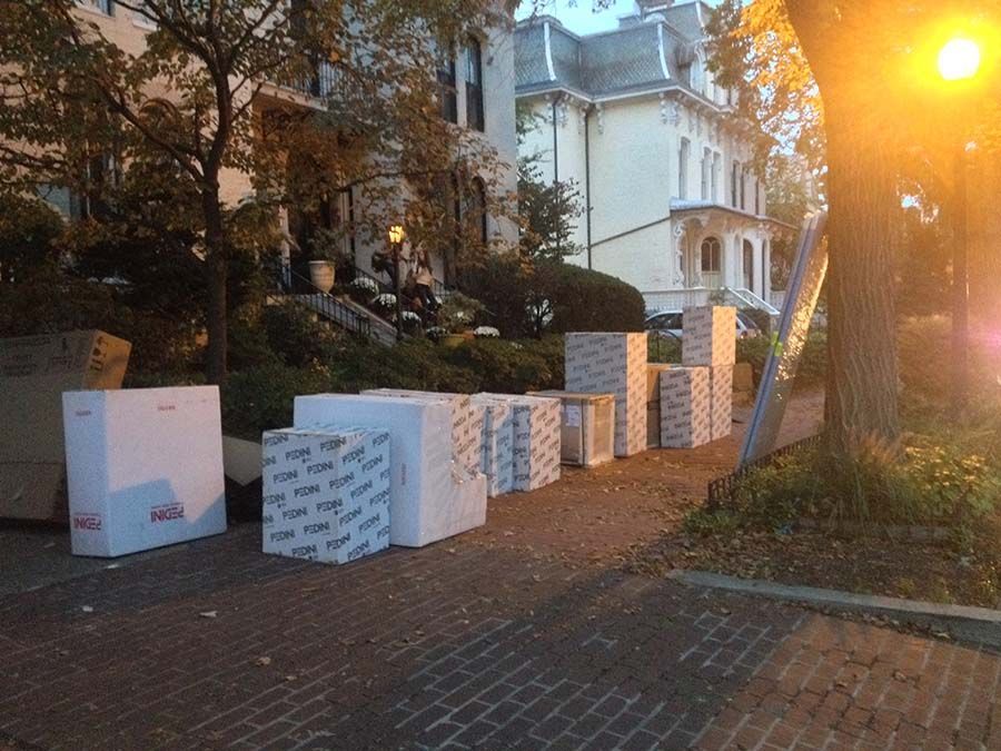 A bunch of boxes are sitting on the sidewalk in front of a house from Cupboard Wagon cabinet delivery services
