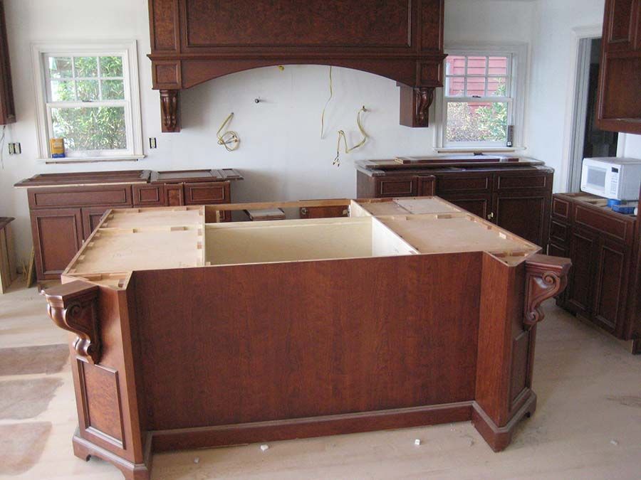 A kitchen with a large wooden island in the middle from Cupboard Wagon cabinet delivery services