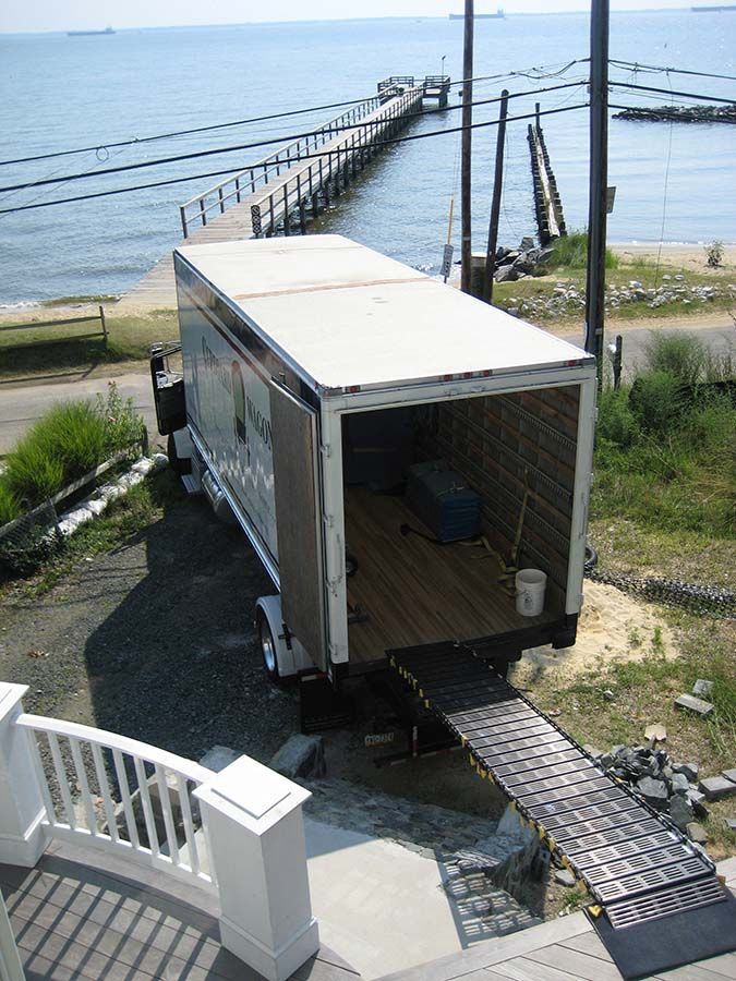 A moving truck is parked in front of a pier overlooking the ocean from Cupboard Wagon cabinet delivery services