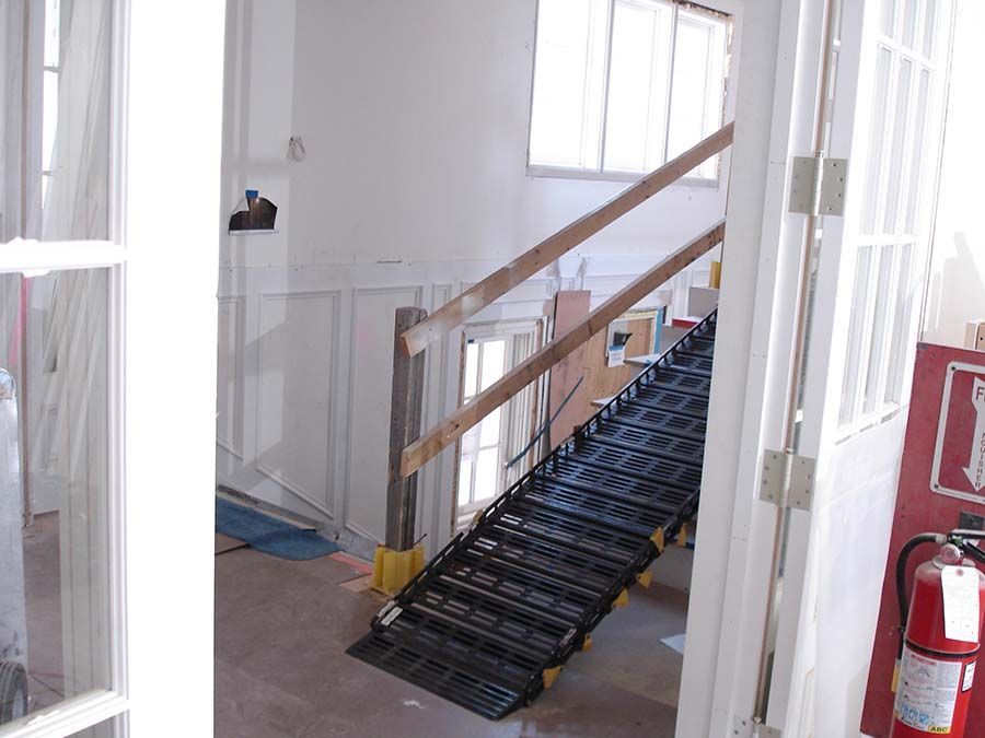 A fire extinguisher is next to a staircase in a building from Cupboard Wagon cabinet delivery services