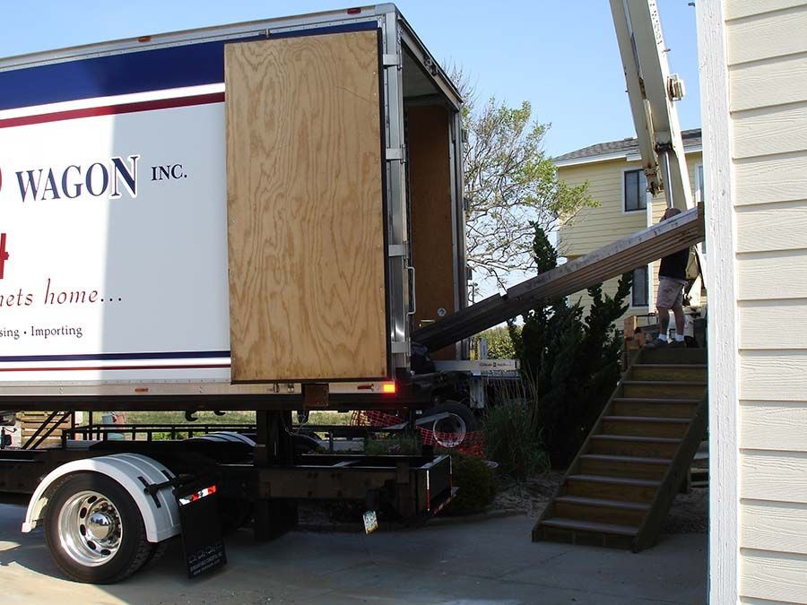 A wagon inc truck is parked in front of a house from Cupboard Wagon cabinet delivery services