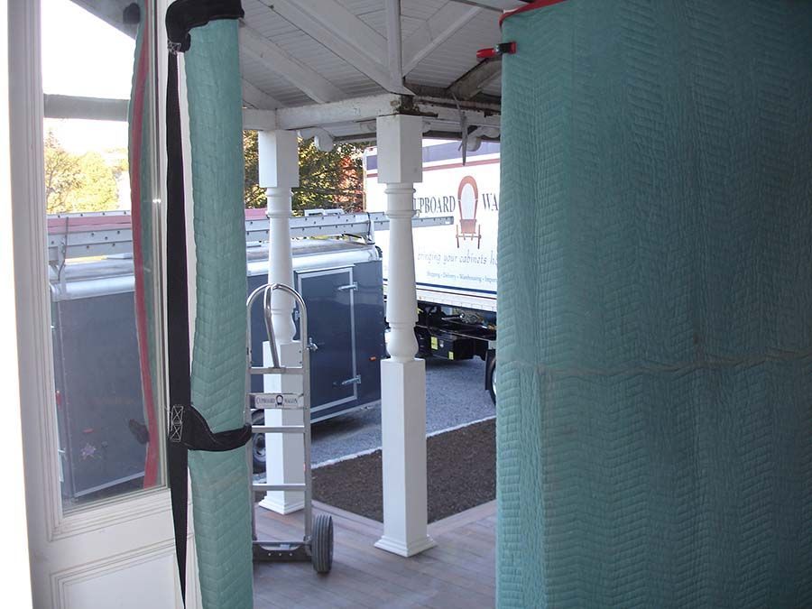 A white truck with the letter o on the side of it from Cupboard Wagon cabinet delivery services