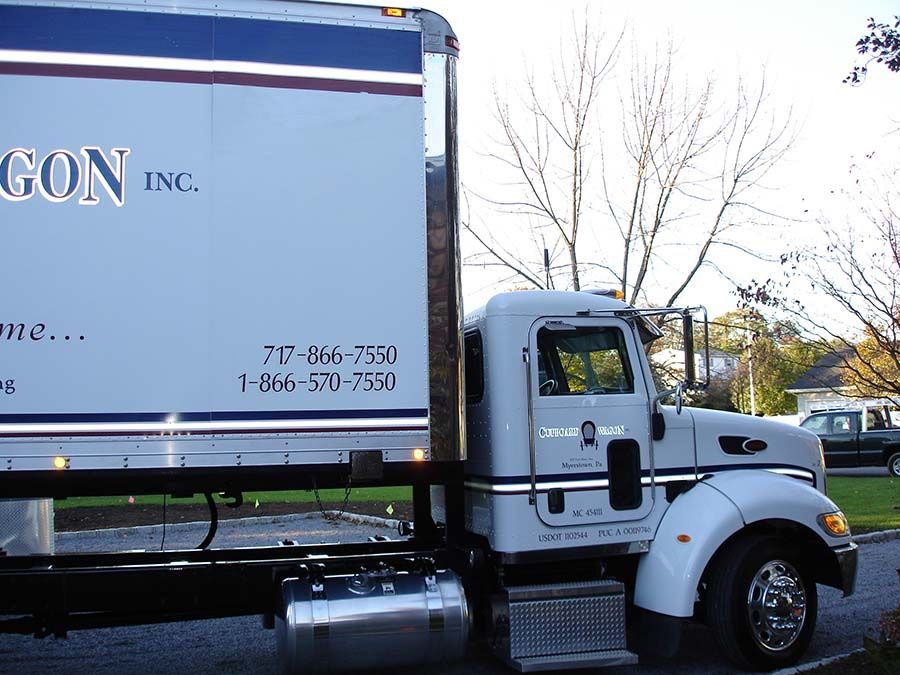 A white truck with the word gon on the side from Cupboard Wagon cabinet delivery services