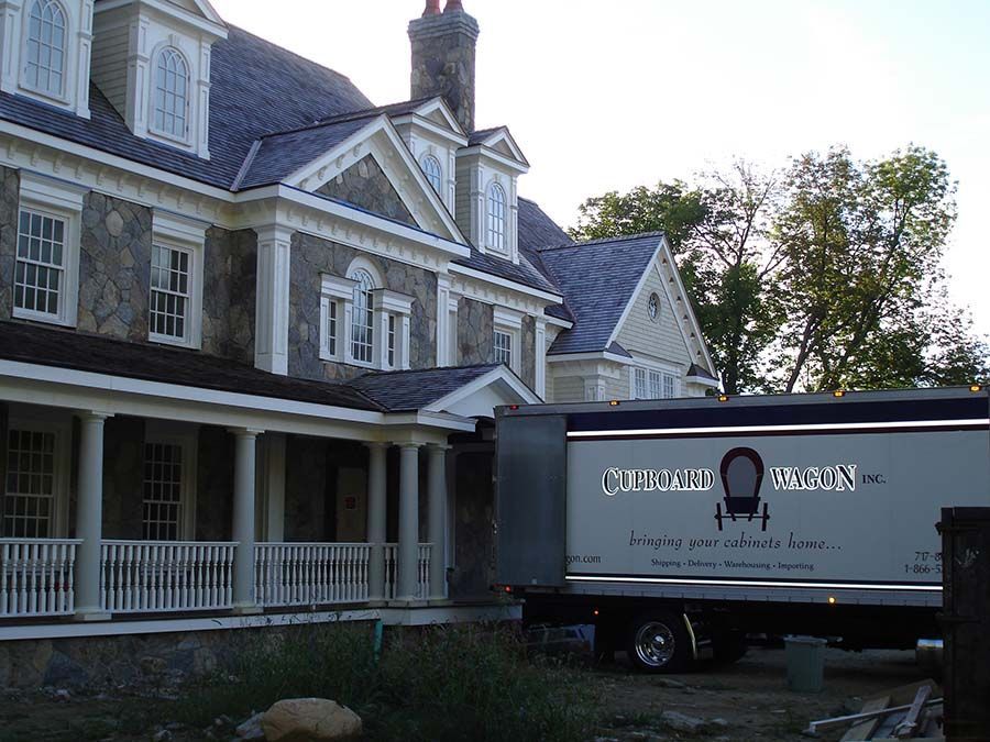 A large house with a moving truck parked in front of it from Cupboard Wagon cabinet delivery services