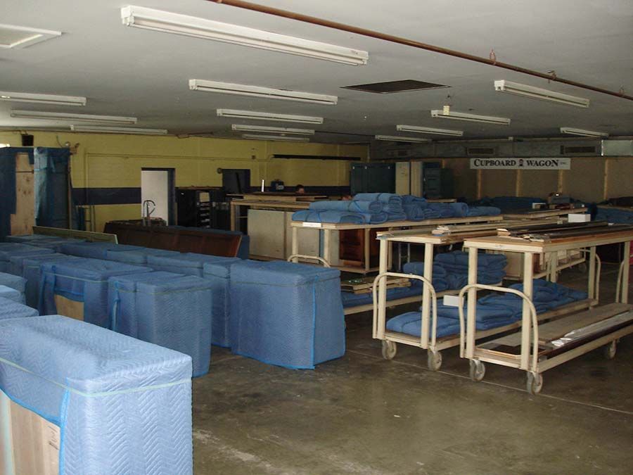 A large room with lots of blue boxes and carts from Cupboard Wagon cabinet delivery services