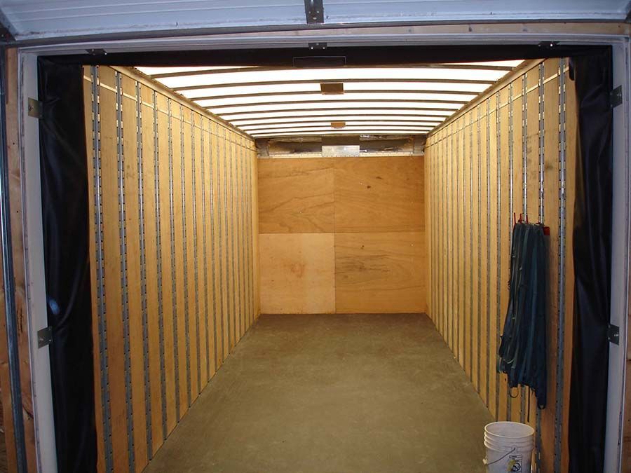 An empty garage with a bucket on the floor from Cupboard Wagon cabinet delivery services