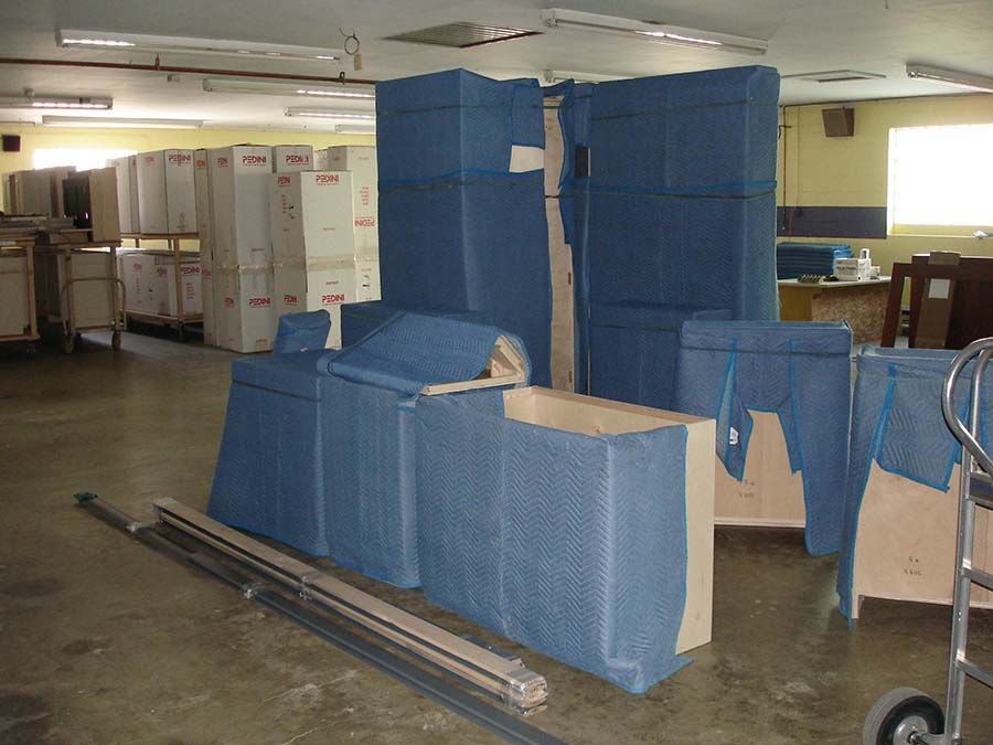 A warehouse filled with blue boxes and pieces of furniture from Cupboard Wagon cabinet delivery services