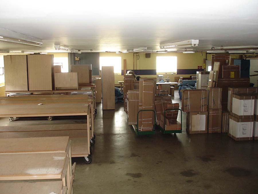 A large warehouse filled with lots of cardboard boxes from Cupboard Wagon cabinet delivery services