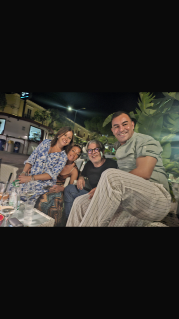 Un gruppo di persone posa per una foto mentre sono sedute a un tavolo.