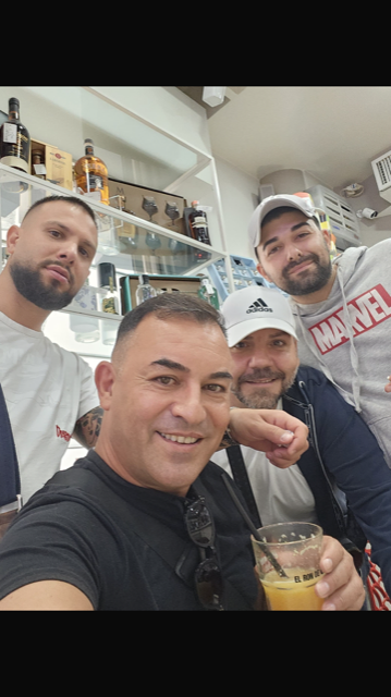 Un gruppo di uomini posa per una foto e uno di loro indossa una maglietta della Marvel.