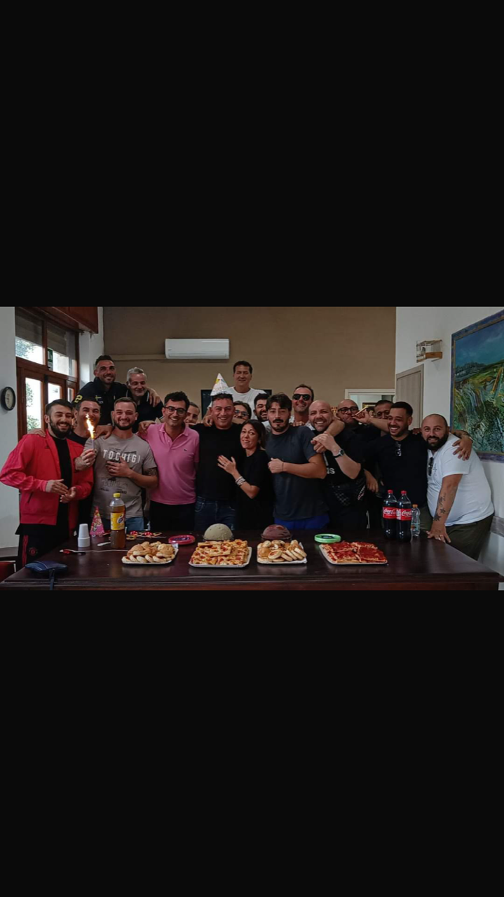 Un gruppo di persone posa per una foto davanti a un tavolo.