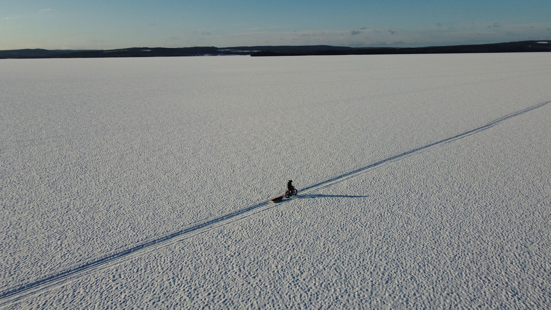 An aerial view of a person sledding down a snow covered field.