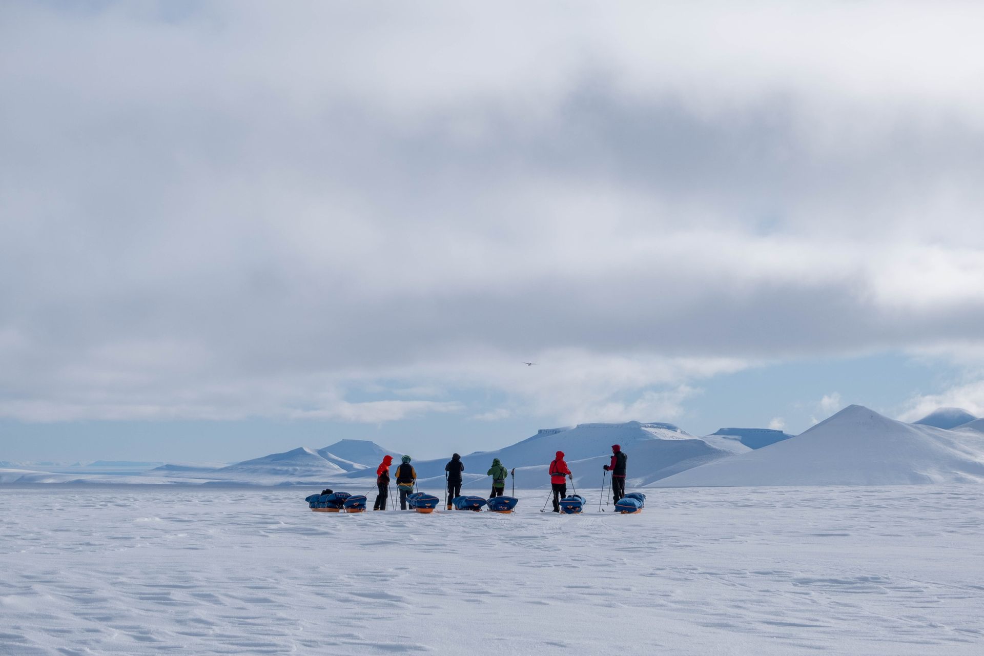 A group of people are standing on top of a snow covered field.