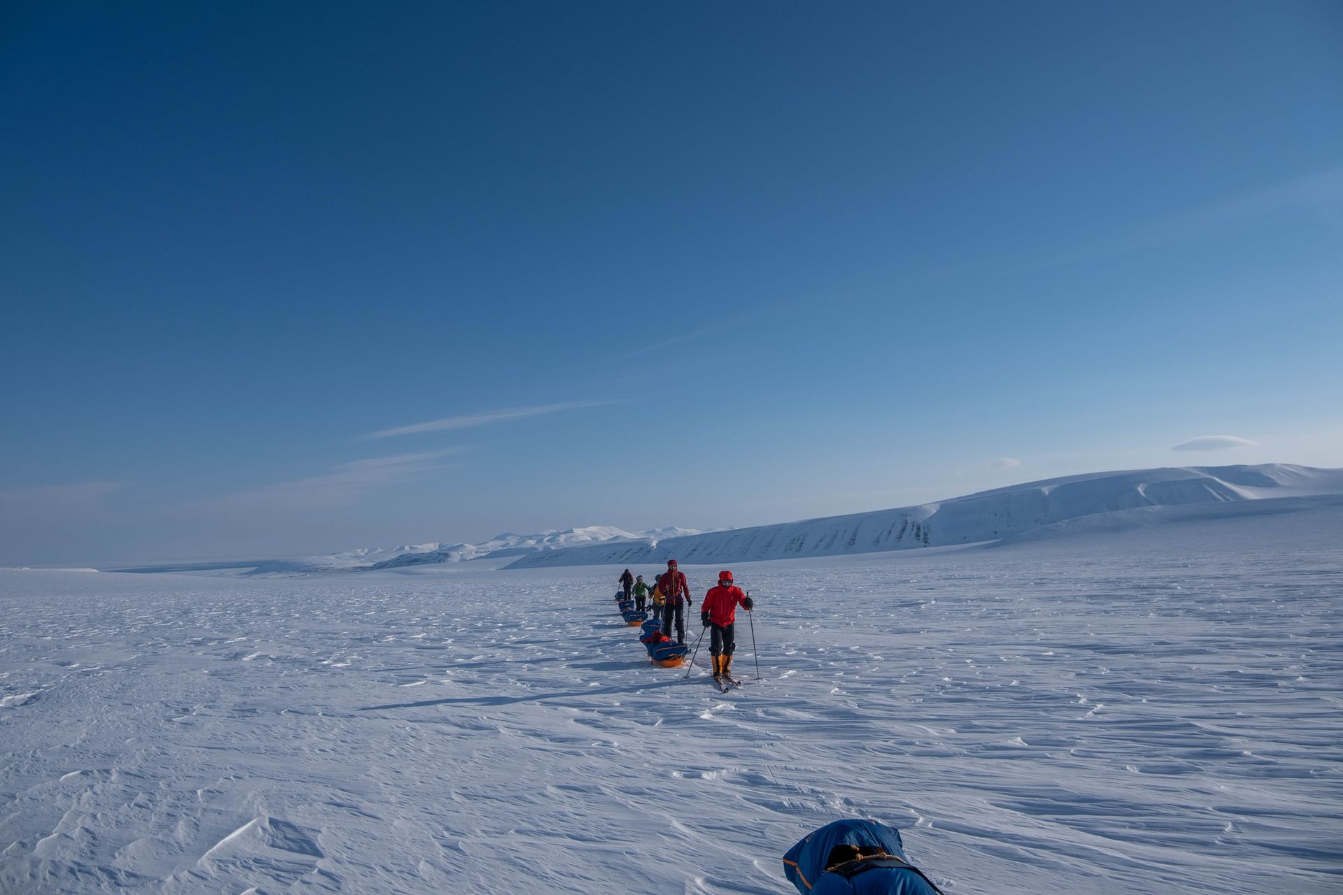 A group of people are walking through a snowy field.