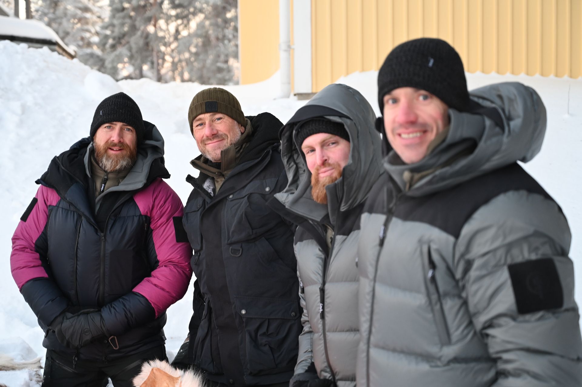 A group of men are posing for a picture in the snow