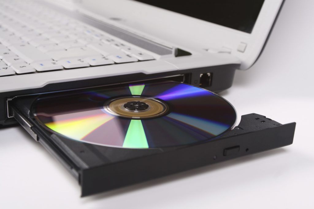 A cd is being inserted into a laptop