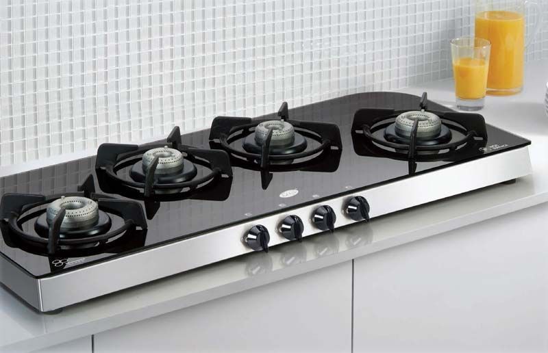 A gas stove with four burners is sitting on a counter.