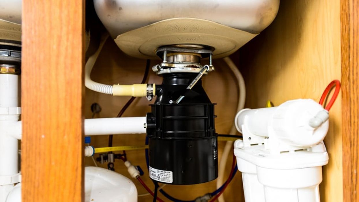 A kitchen sink with a garbage disposal underneath it.