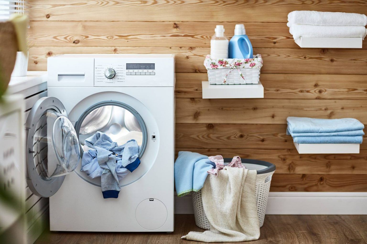 A washing machine is filled with clothes in a laundry room.
