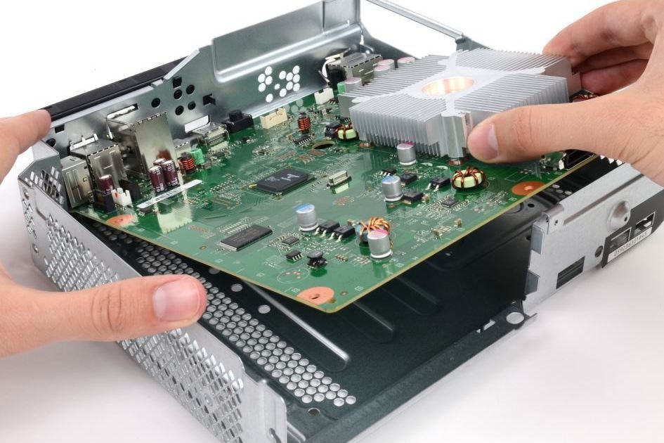 A person is removing a motherboard from a computer