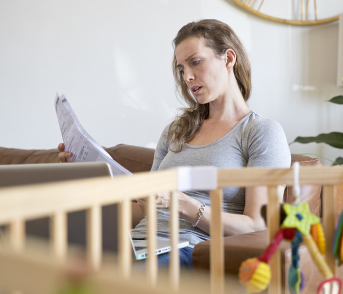 Stressed Mother With Laptop Looking At Household Bills