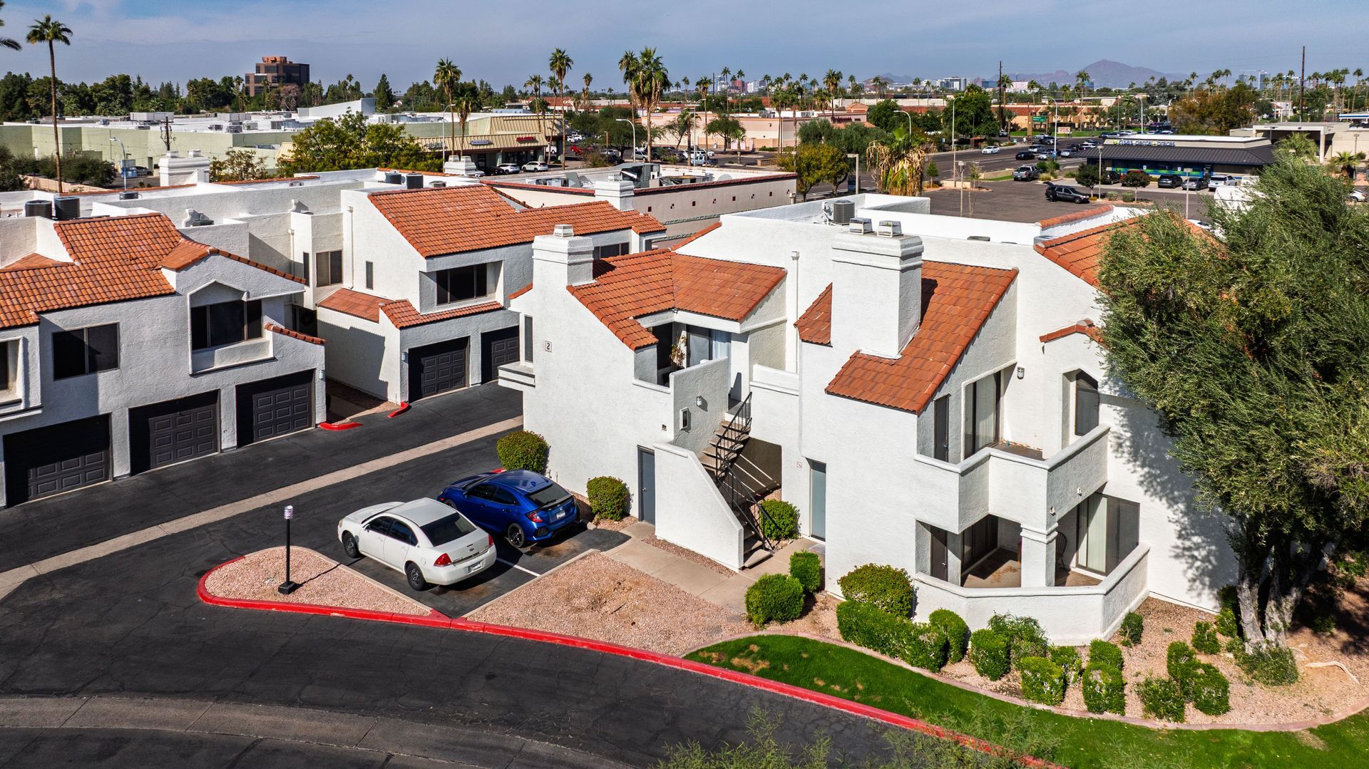 Office building with a red-tile roof and a long flag pole on a sunny day. Other buildings in the background. Experience elevated Tempe, Arizona apartments at Talavera Apartments.