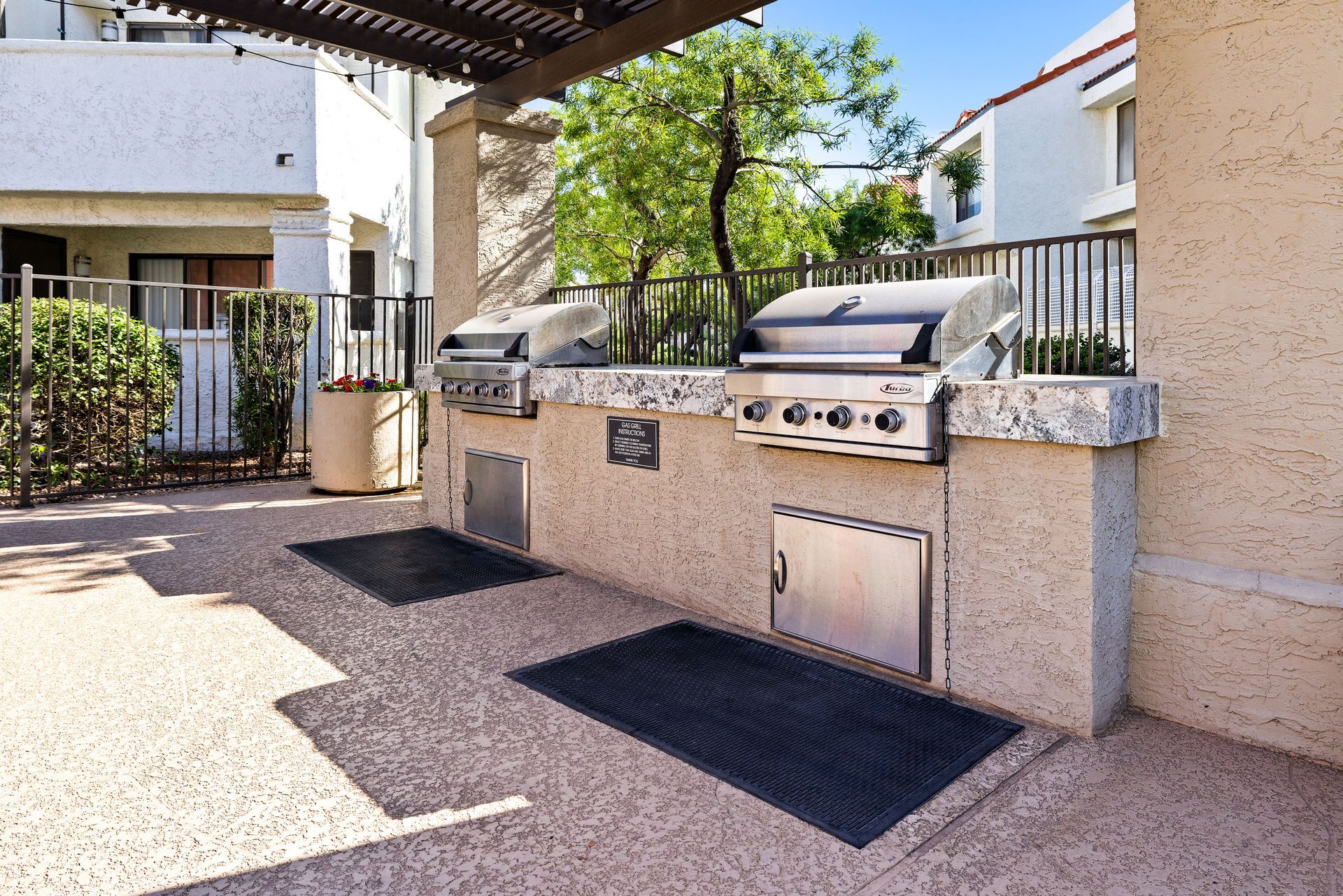 Outdoor grilling area with two stainless steel grills and a counter on a stucco structure. Find your ideal Tempe AZ apartment rentals at Talavera Apartments today.