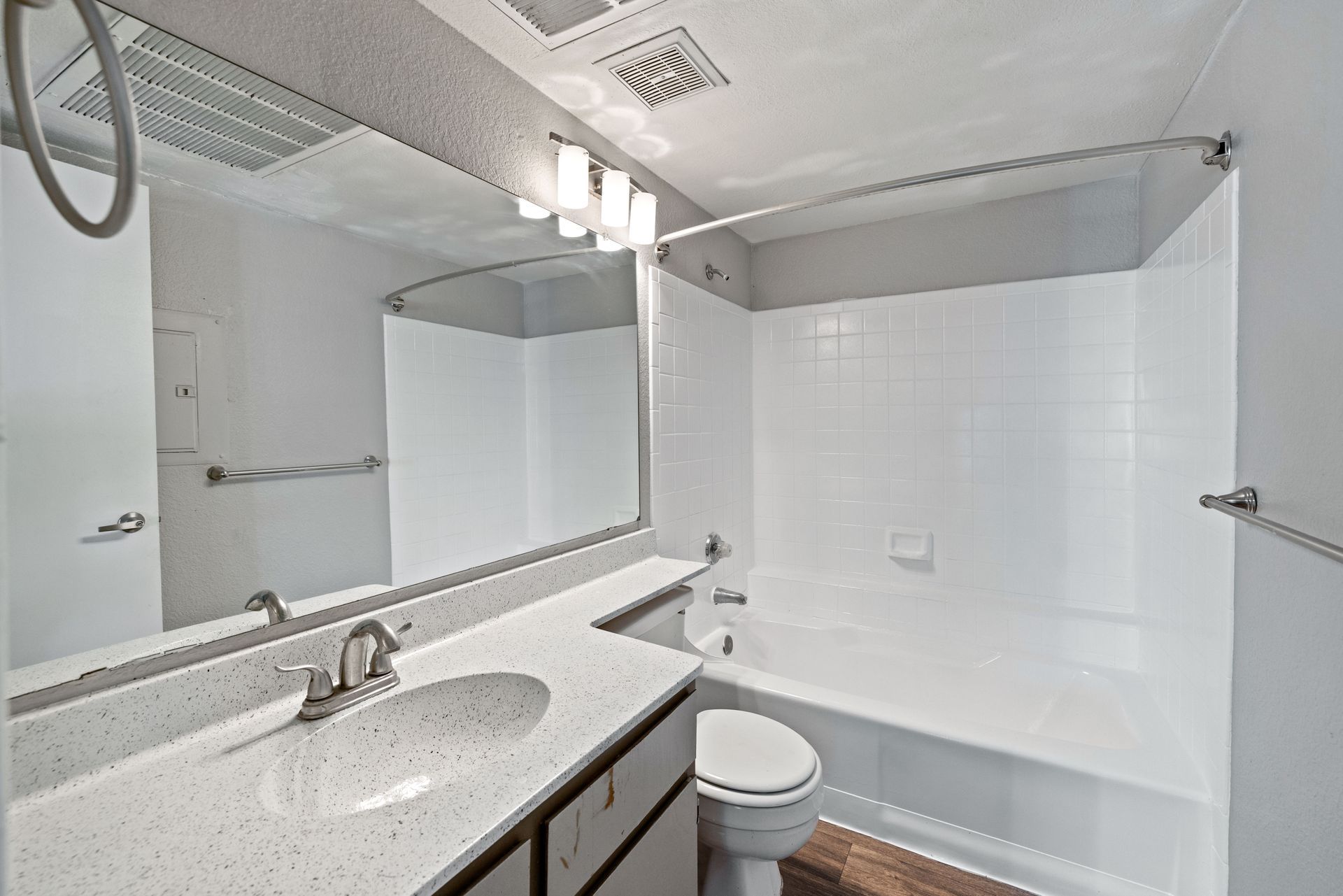 Bathroom with white tub, vanity, and toilet; large mirror; gray ceiling; neutral-toned walls. Talavera Apartments makes pet-friendly apartments in Tempe AZ easy to love.