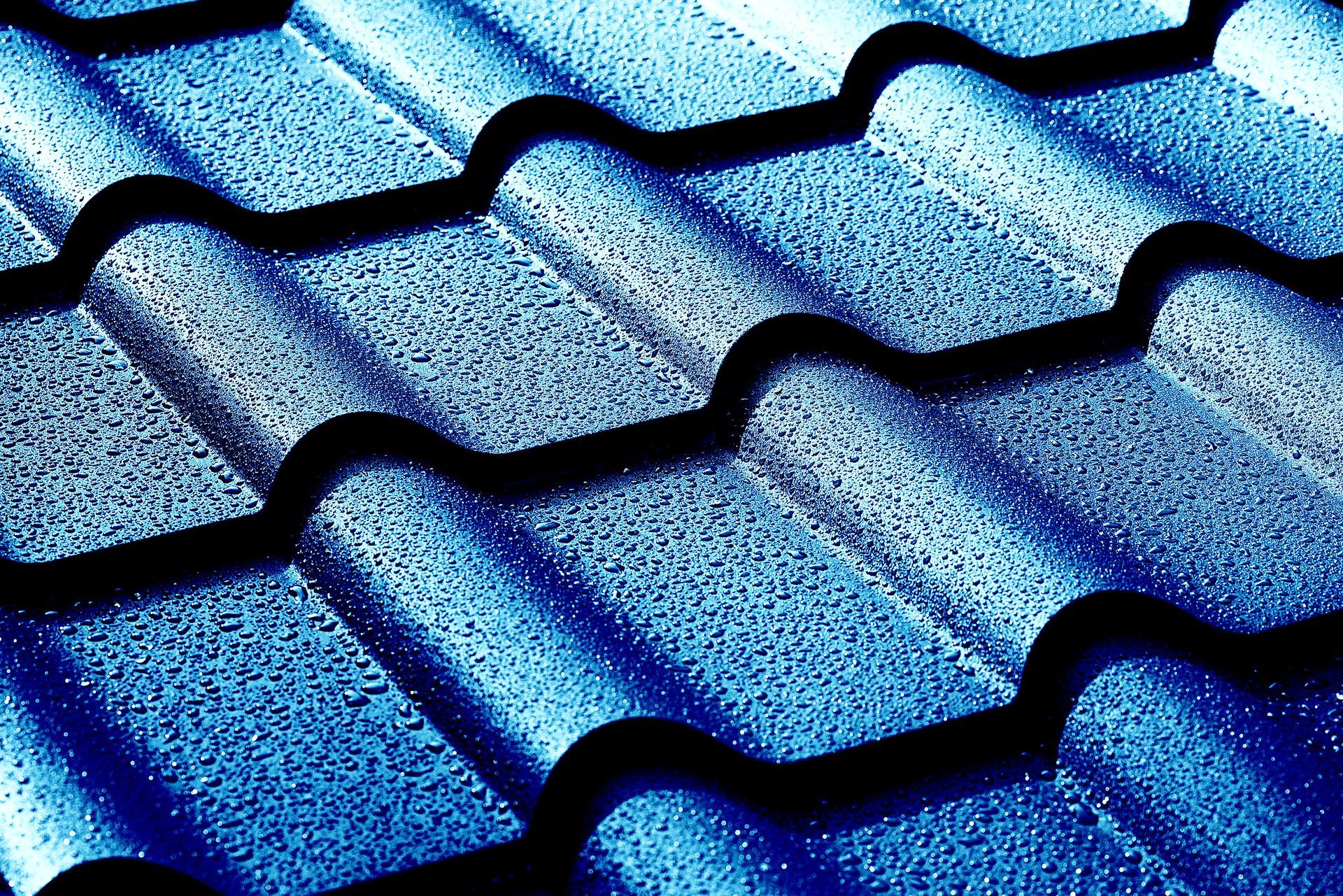 Blue metal roof tiles with a textured, speckled surface. Blue metal roof tiles with a textured, speckled surface.