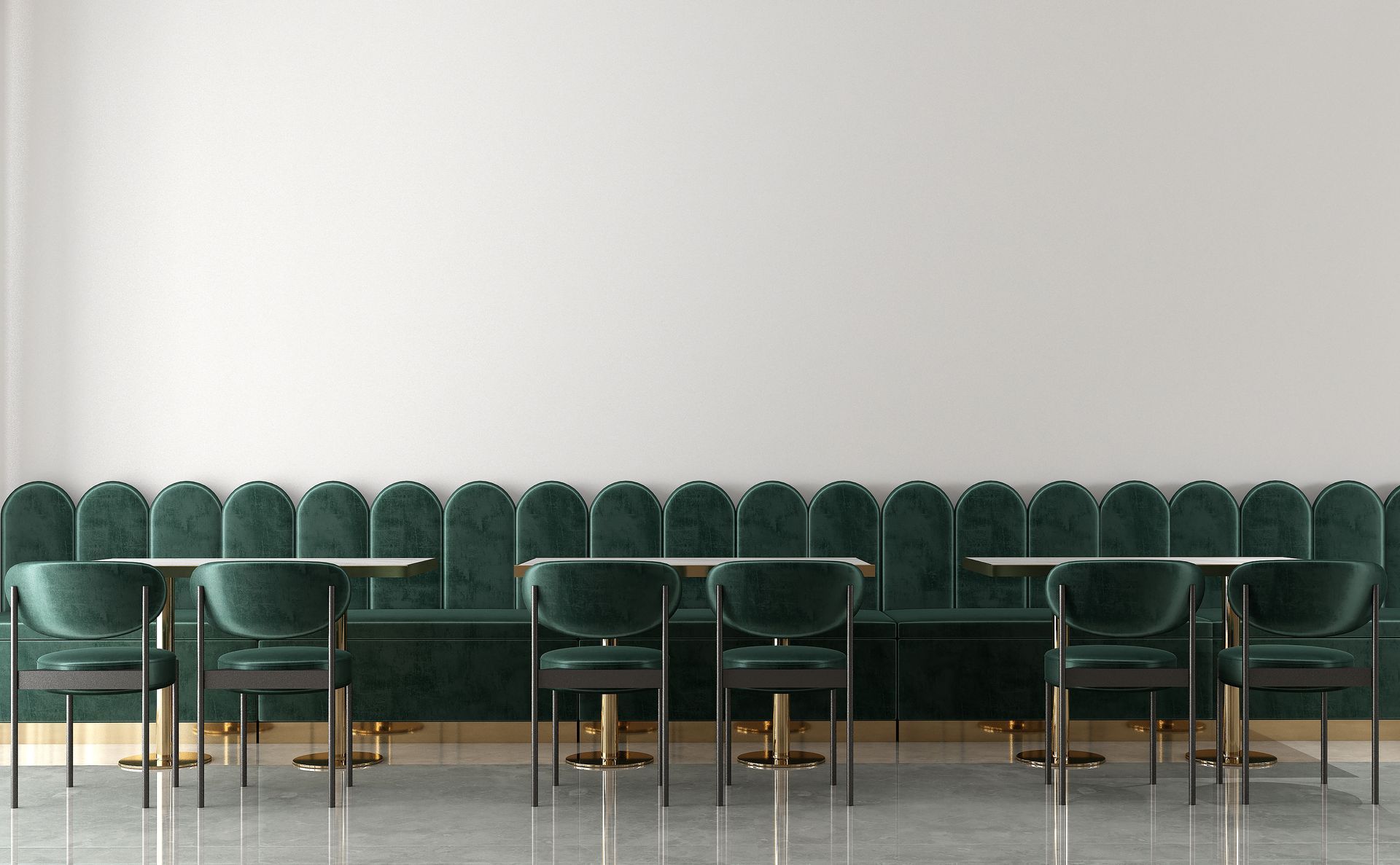 Interior with green velvet booth seating, gold accents, and round tables against a white wall. Interior with green velvet booth seating, gold accents, and round tables against a white wall.