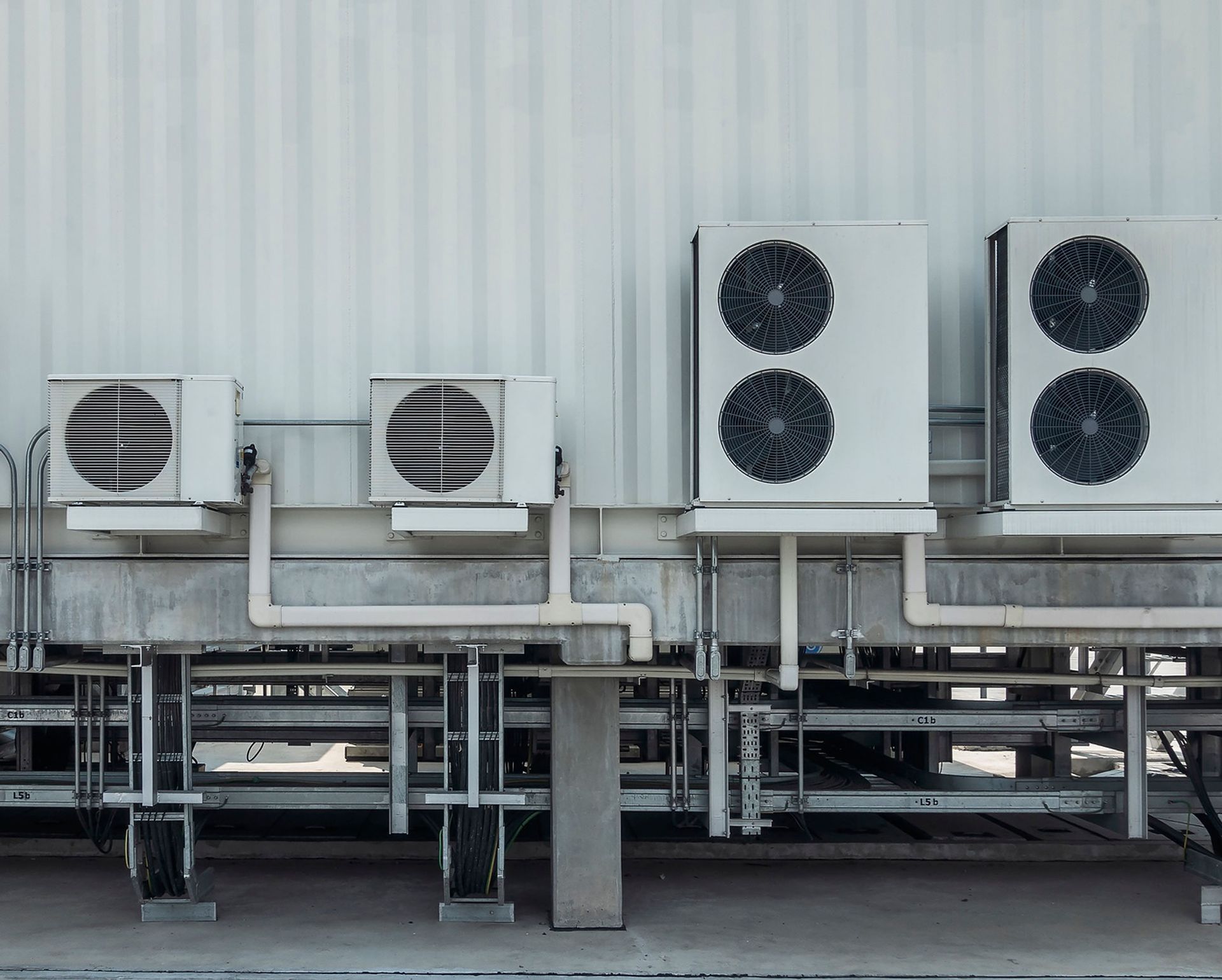 Une rangée de climatiseurs sur le côté d'un bâtiment.
