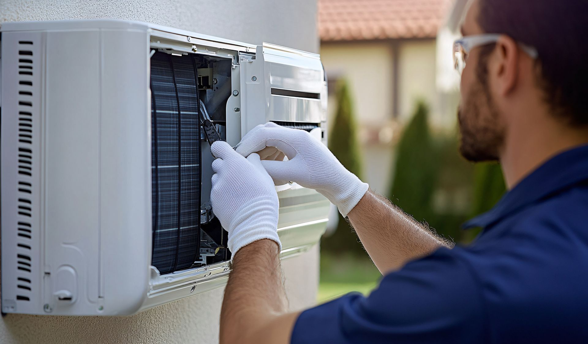 Un homme portant des gants blancs travaille sur un climatiseur.