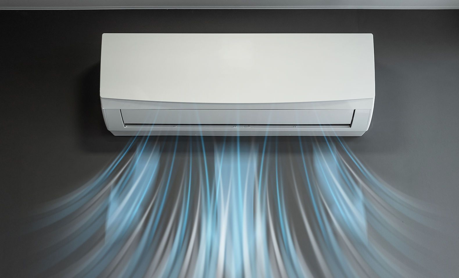 Un climatiseur blanc est accroché à un mur et l'air en sort.
