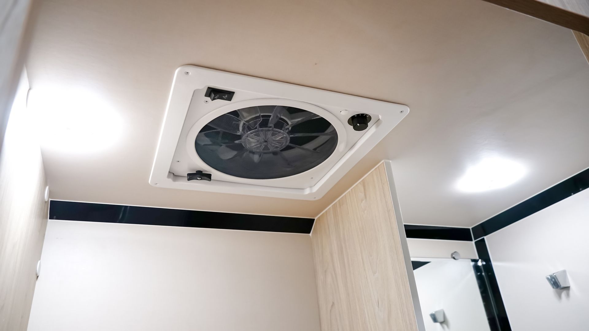 Un ventilateur est suspendu au plafond d'une salle de bain.