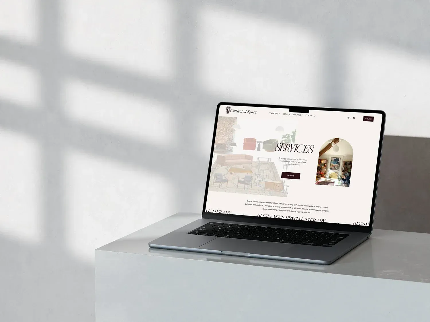 Laptop displaying a website on a white surface with shadow overlay.