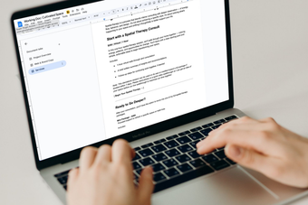 Person typing on a laptop, viewing a document on the screen.