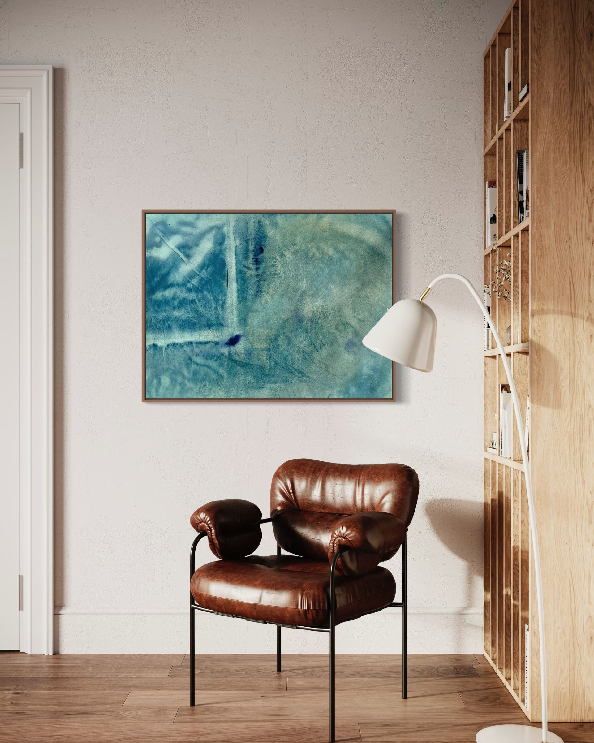Leather armchair, abstract blue painting, and bookshelf in a room with a white wall.