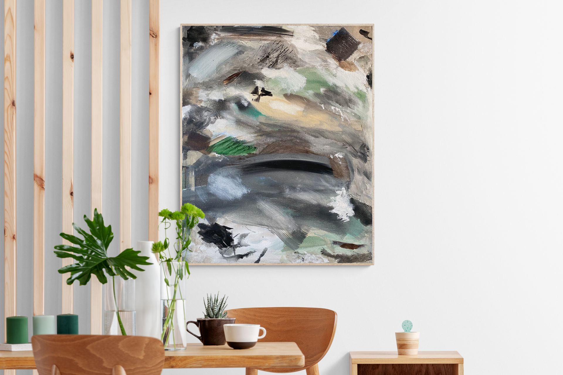Abstract painting in neutral tones displayed on a white wall, over a wooden dining table.