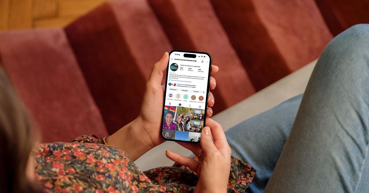 Hand holding a phone displaying an Instagram profile for a real estate business.