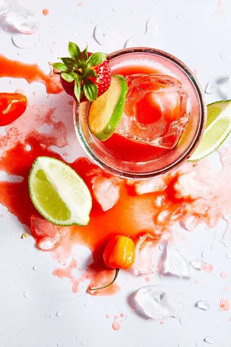 Person using a laptop, typing at a table near a window. Website visible on screen.