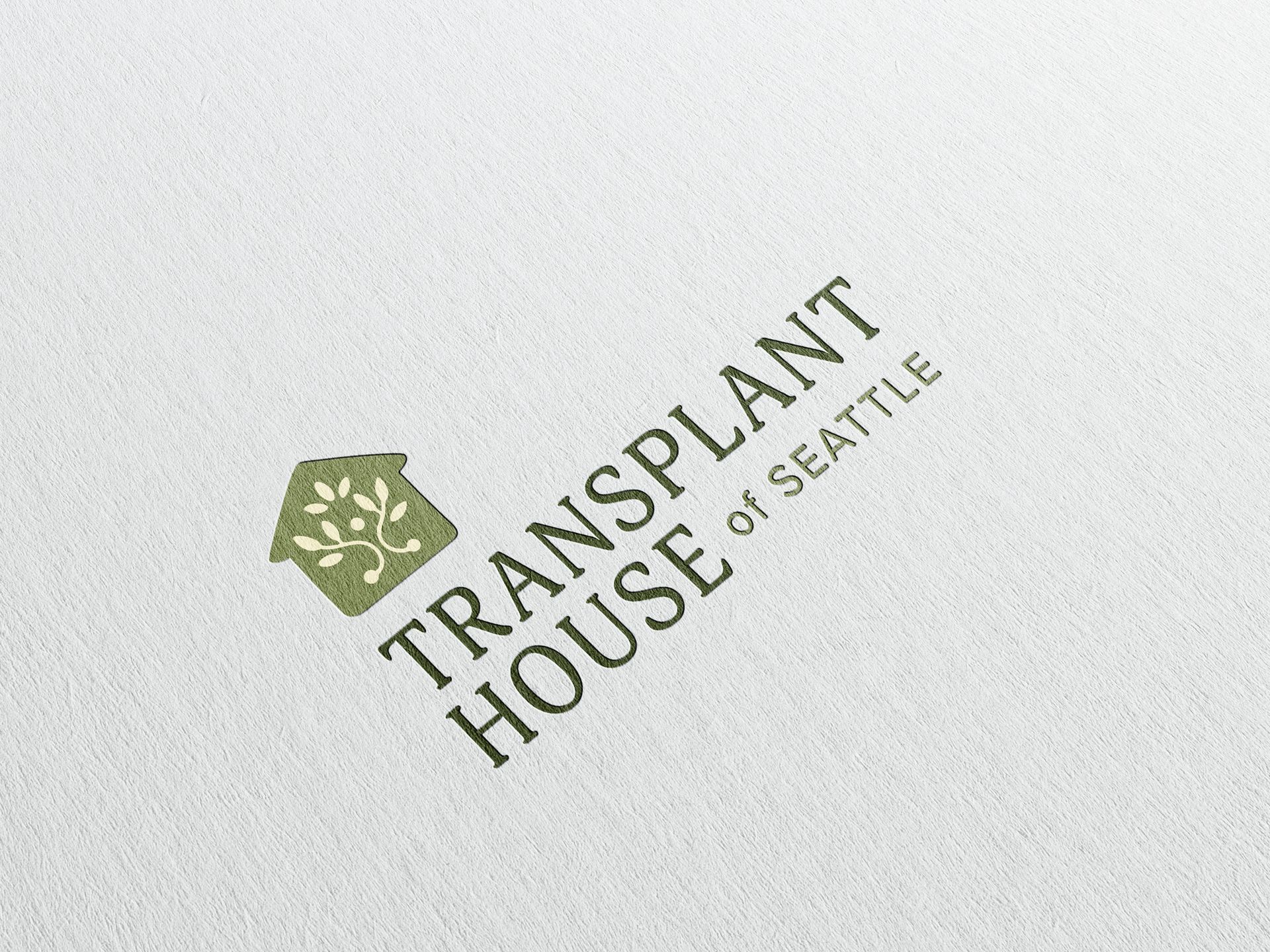 Logo for Transplant House of Seattle, green text and house icon with tree on white background.