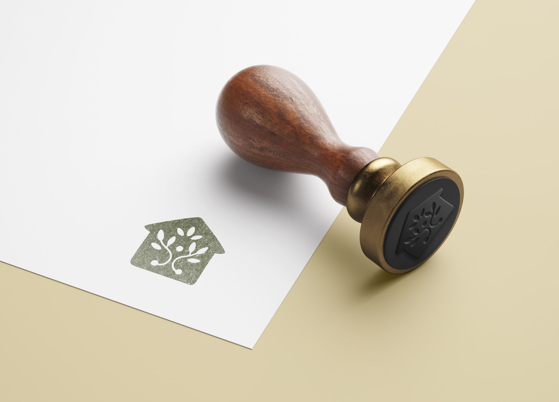 Wooden stamp with a house and tree design on white paper.