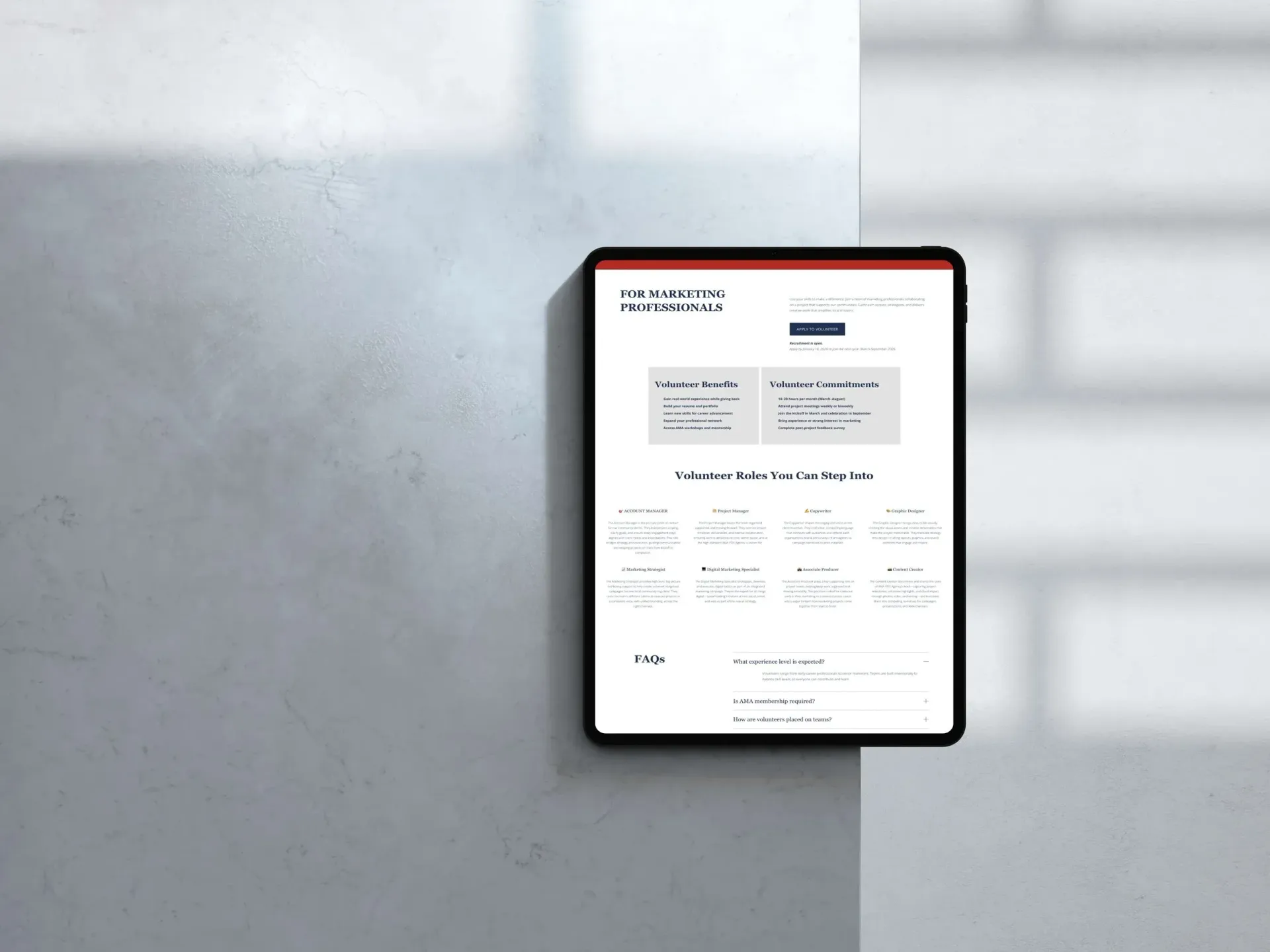 Person using a laptop, typing at a table near a window. Website visible on screen.